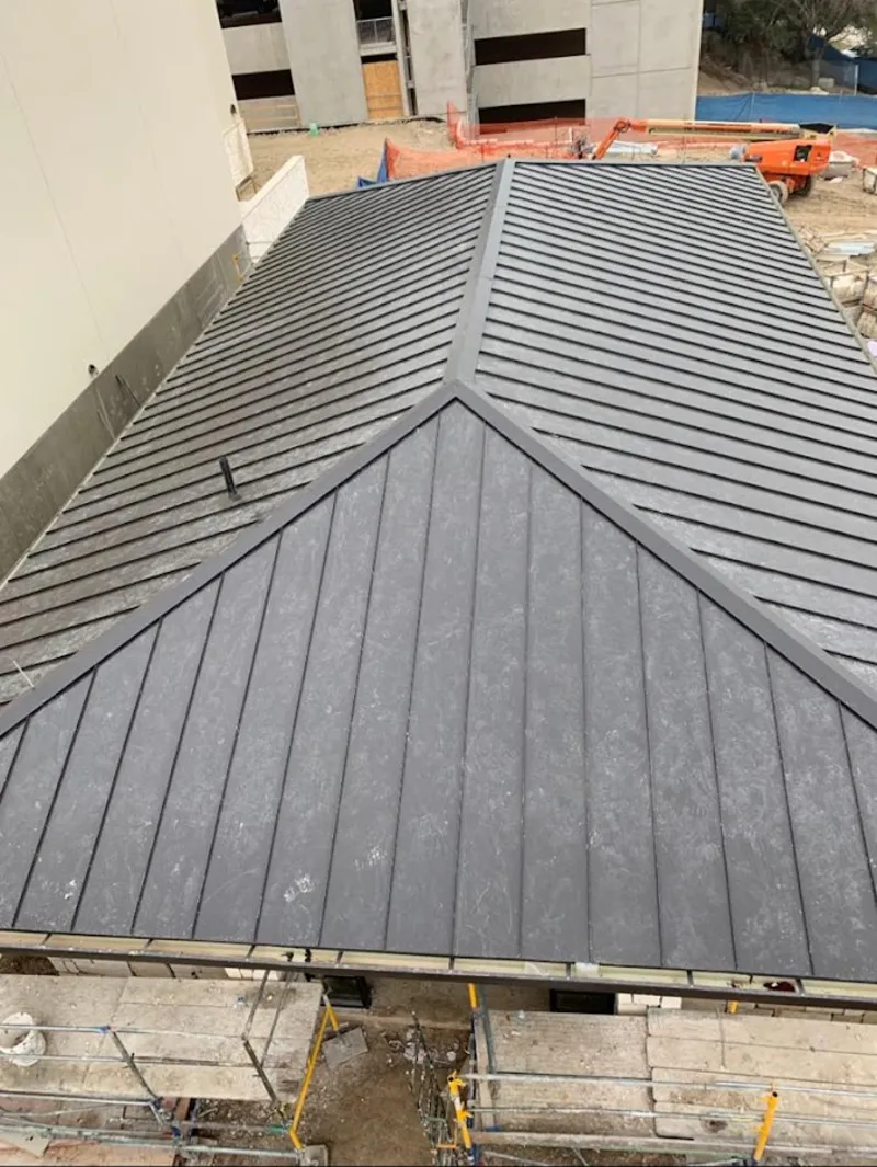 Commercial metal roof construction with crane equipment in St. Marys